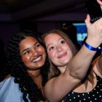 Two grads smile taking selfie at Toast